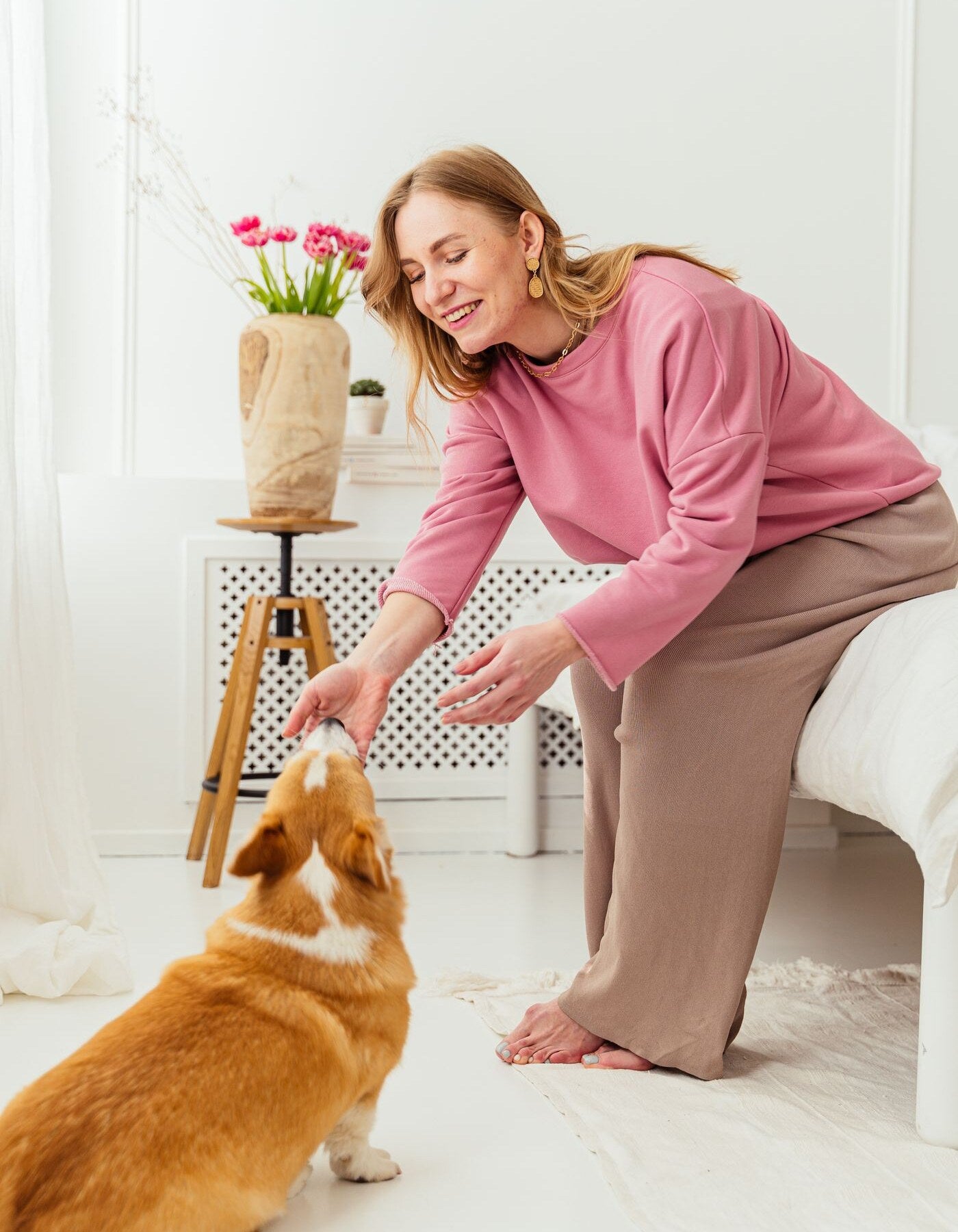 Hundägare leker med sin hund i ett ljust hem
