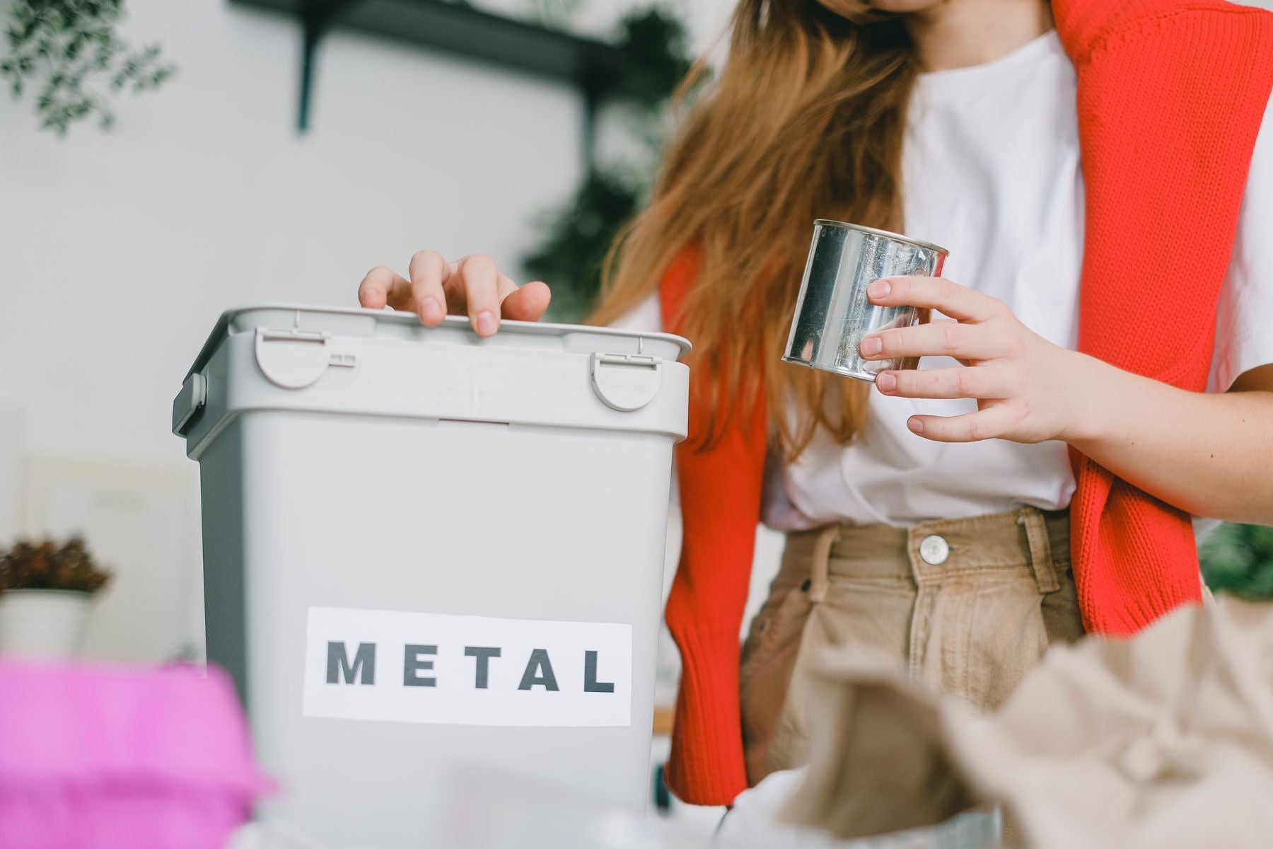 Person sorterar en metallförpackning för återvinning